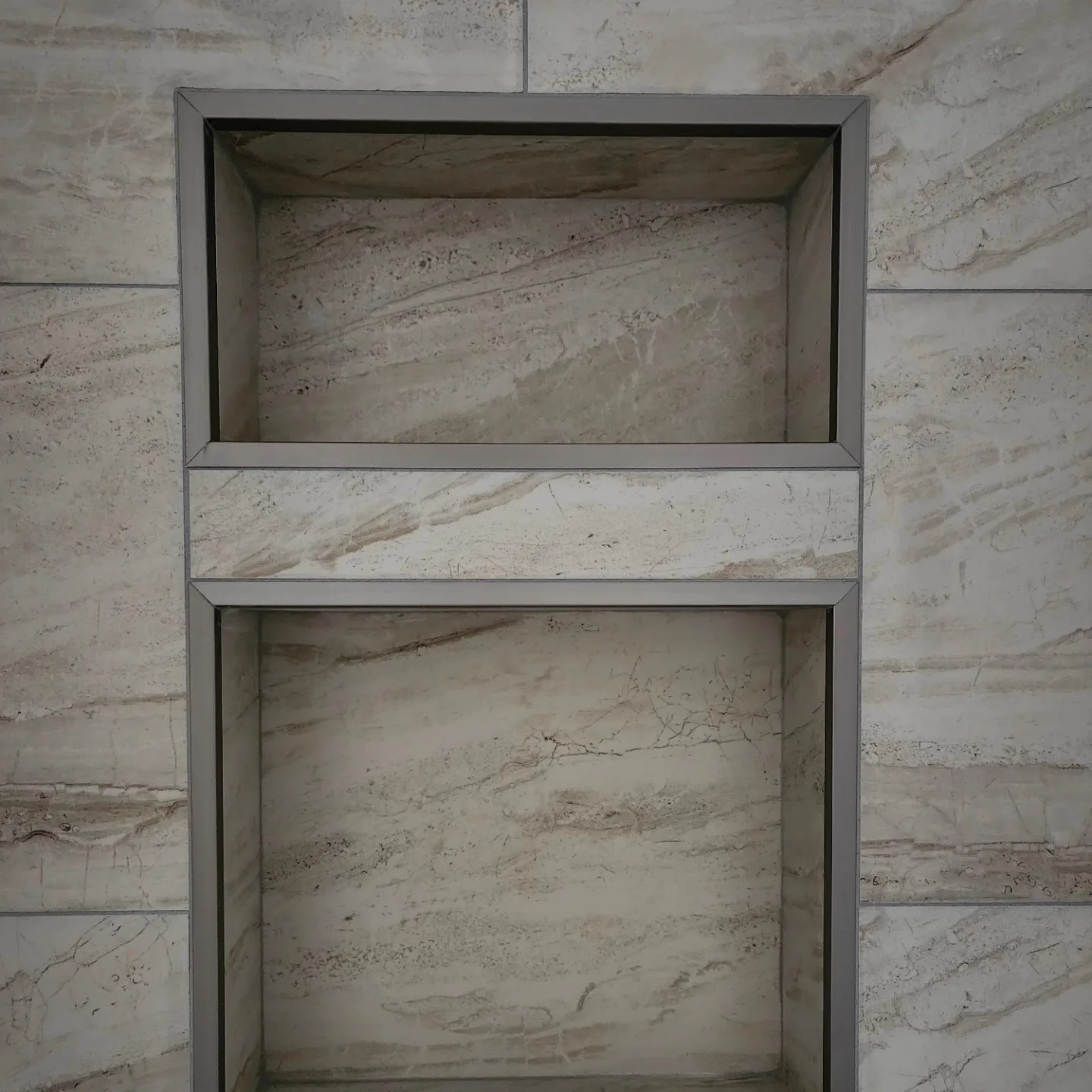 Recessed shower niche shelving in marble tile