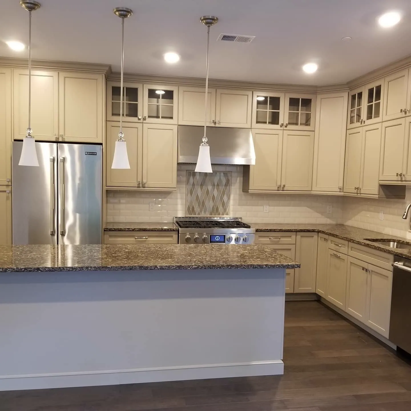 Kitchen with cream cabinets, granite counters, and pendant lighting
